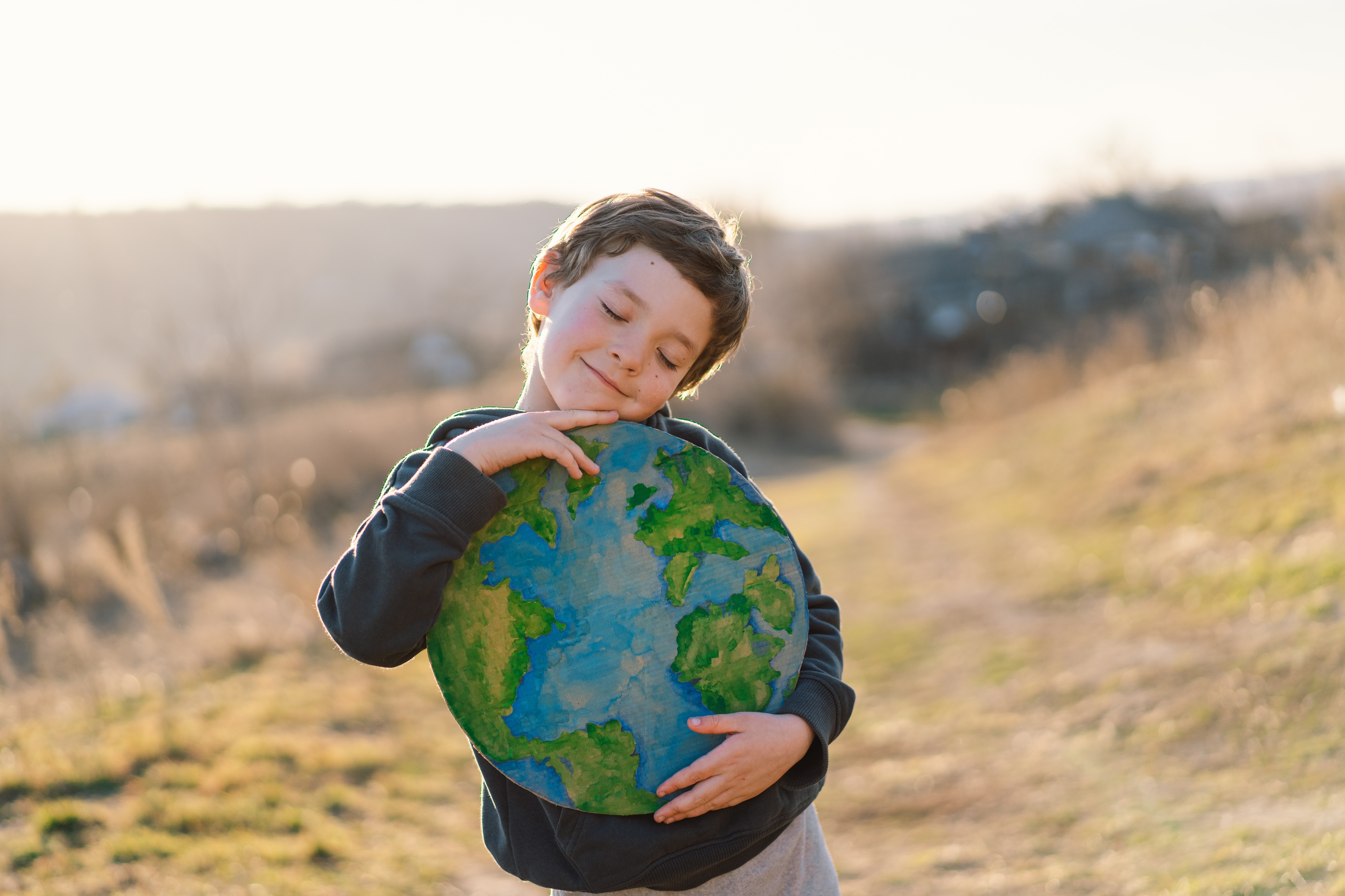 Junge umarmt Planet